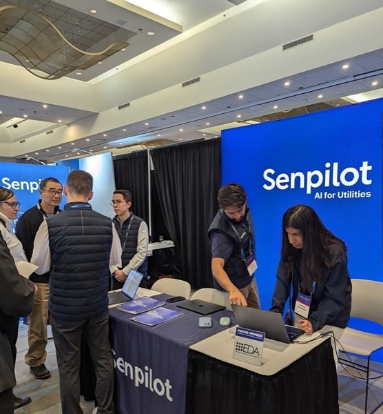 The Senpilot team talking with visitors and working at a conference booth